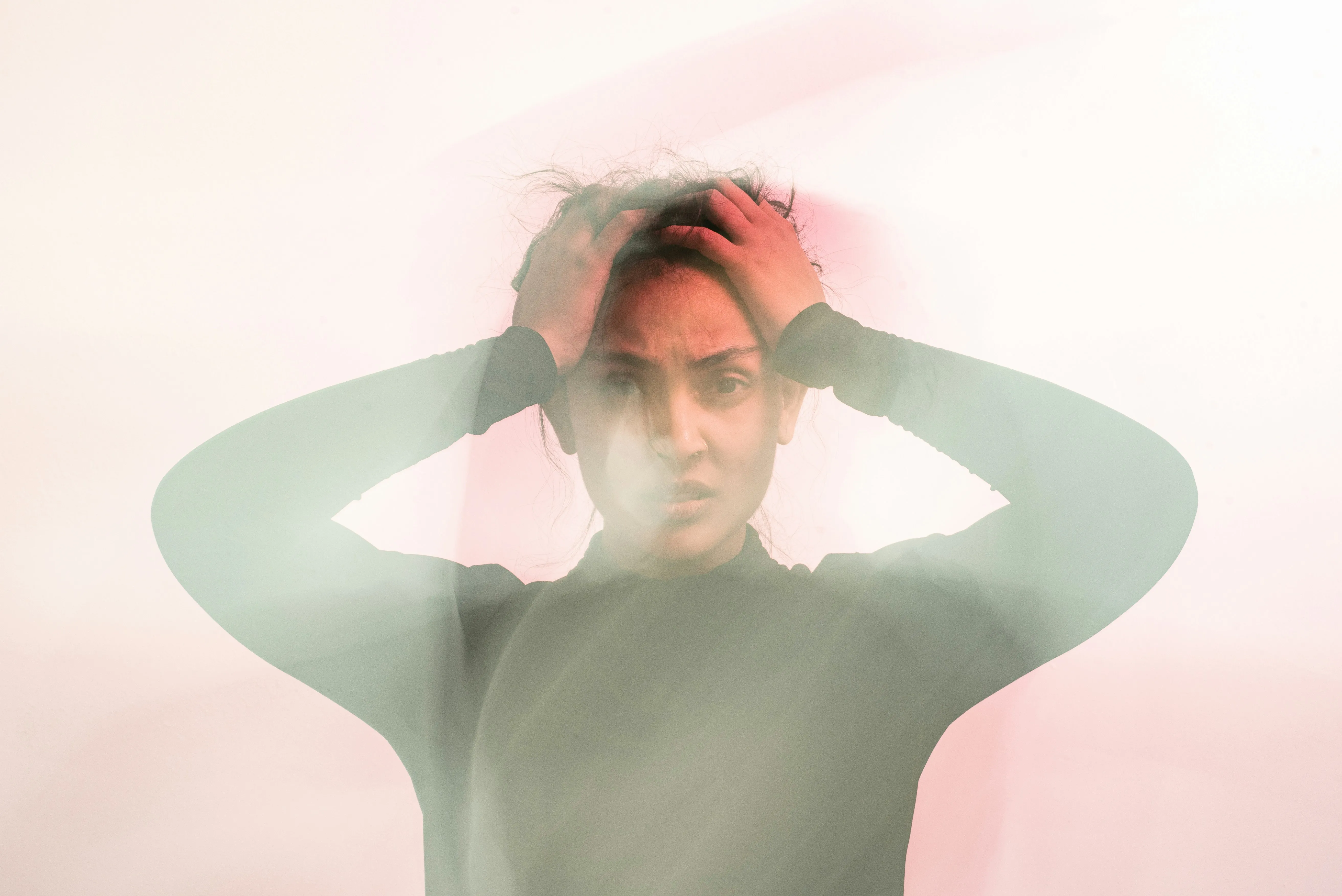 Distressed woman holding her head, illustrating the difference between stress and anxiety